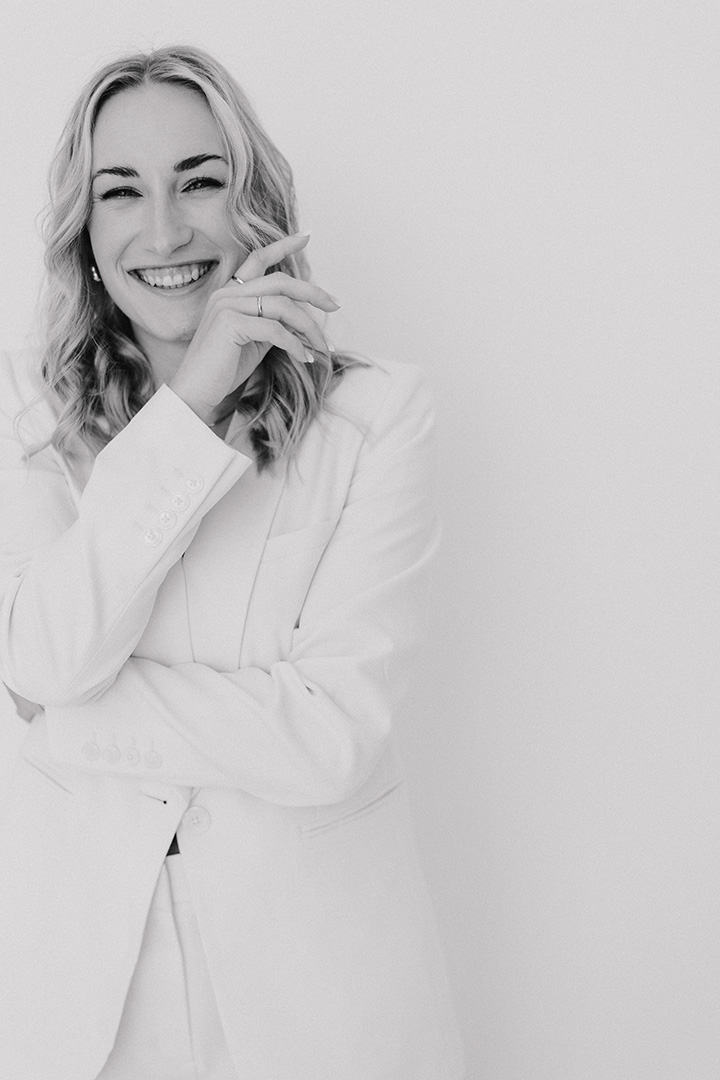 Heike Gosling, Gründerin von feelweb designstudio, lachend im weißen Anzug
